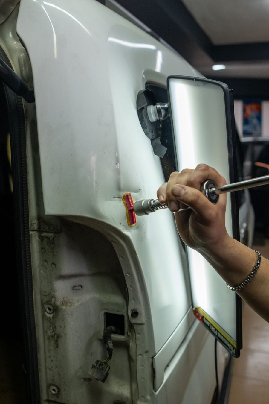 A rod and light board used on a car door dent
