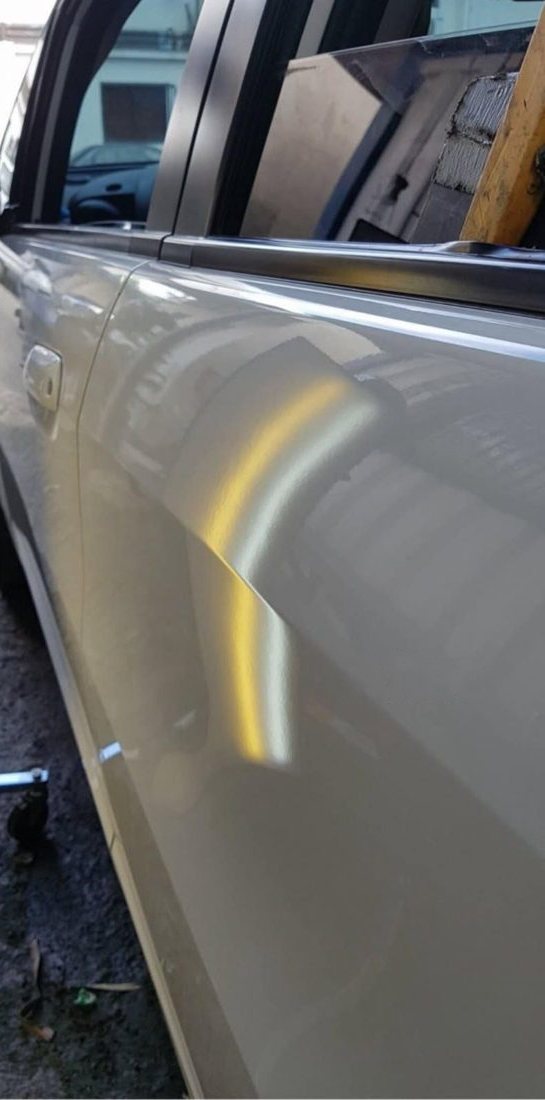 Silver door dent, after