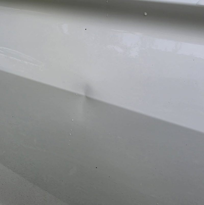 A dent sitting on a fold line of a white door