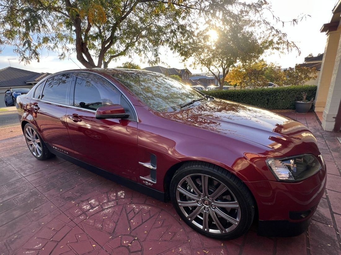 The burgundy sedan before the repair